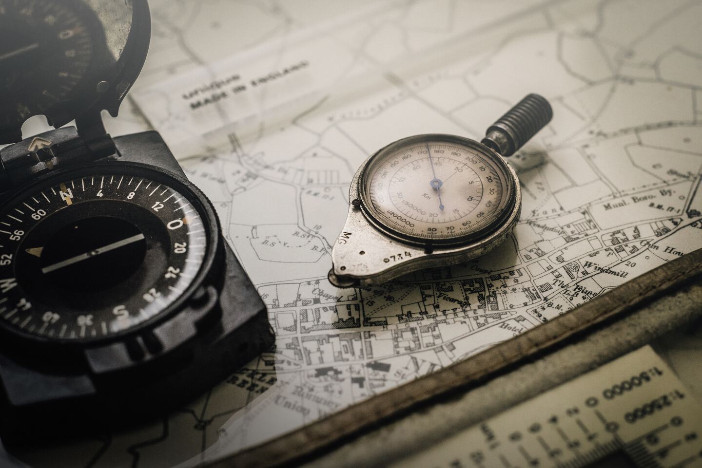 black and gray compass on top of a paper-map