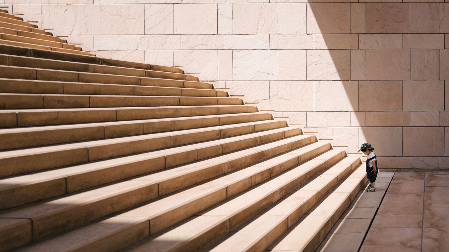 toddler standing in front of beige concrete stair